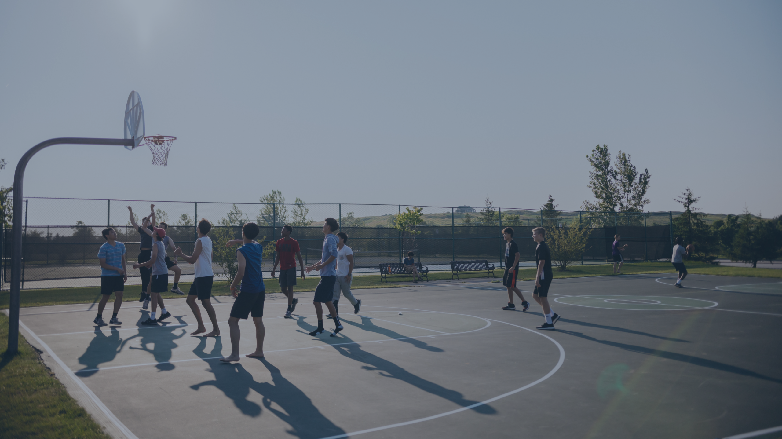 Personer spiller undendørs basketball